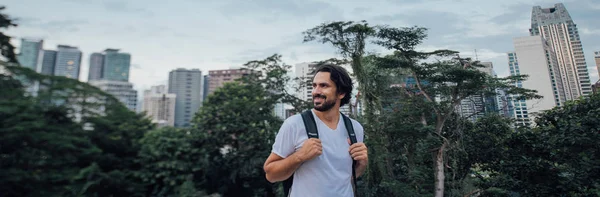 Een man bewondert het uitzicht tegen de achtergrond van wolkenkrabbers — Stockfoto