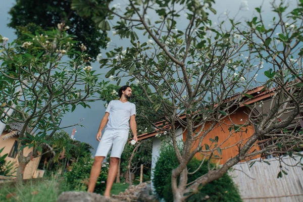 Un hombre vestido de blanco en un jardín tropical —  Fotos de Stock