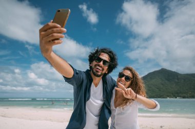 Bir çift aşık tropik bir plajda selfie çekiyor..