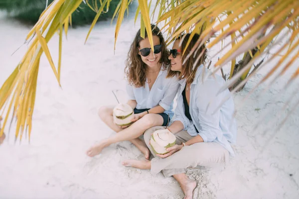 Ένα ζευγάρι ερωτευμένων κοριτσιών με κοκτέιλ σε μια τροπική παραλία. — Φωτογραφία Αρχείου