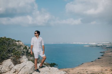 A man on the rocks overlooking the sea