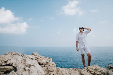 A man on the rocks overlooking the sea