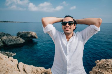 A man on the rocks overlooking the sea