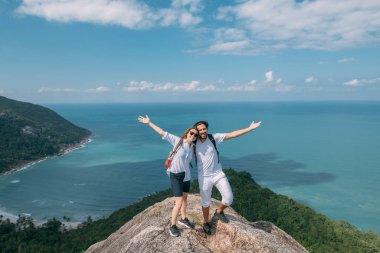 Bir çift, bir kayanın üzerinde destansı bir bakış açısıyla duruyor.