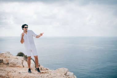 A man on the rocks overlooking the sea