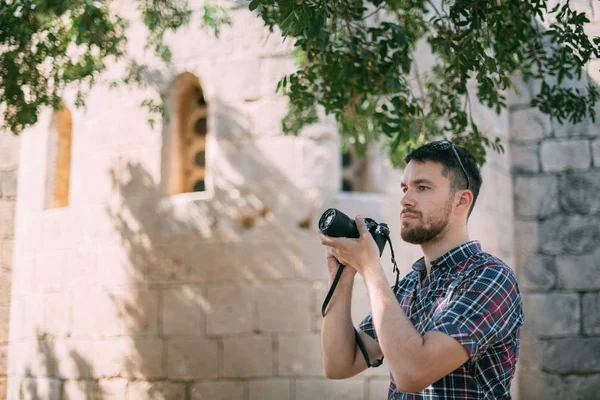 Ein Mann mit einer Kamera in der Nähe des alten Tempels — Stockfoto