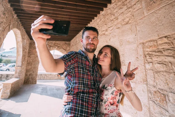 Een jong stel geliefden neemt een selfie tegen de achtergrond van — Stockfoto