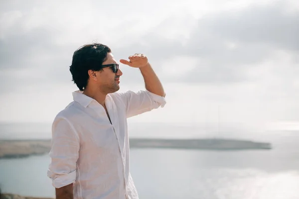 Een man op de rotsen met uitzicht op de zee — Stockfoto