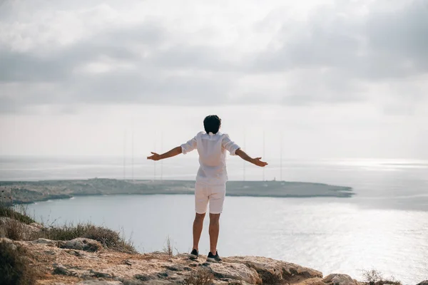 Чоловік на скелях з видом на море — стокове фото