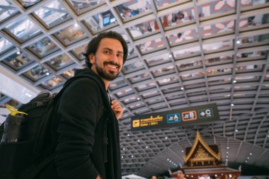 Havaalanında sırt çantalı genç bir adam.