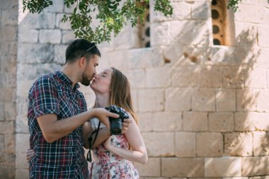Lovers take pictures of attractions near the stone wall of the temple. A couple of newlyweds admire the ancient church. Honeymoon on Travel