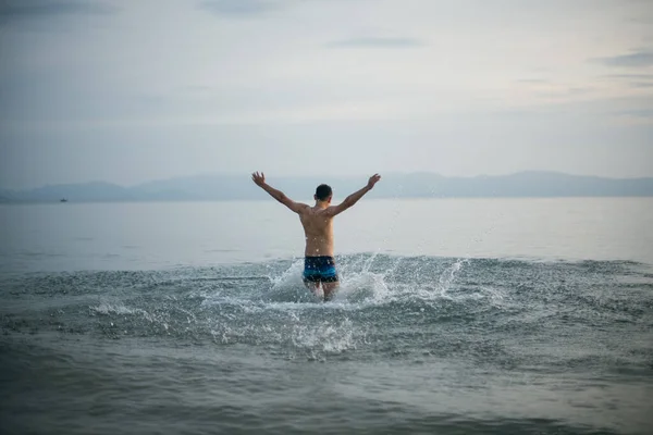 Hombre Disfruta Noche Océano Atardecer Joven Bañador Aguas Tranquilas Océano —  Fotos de Stock