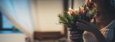 Bir kadının ellerinde bir buket çiçek. Uluslararası Kadınlar Günü. Genç bir kız lalelerin elinde topallıyor..