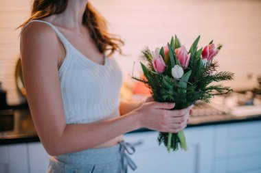 Bir kadının ellerinde bir buket çiçek. Uluslararası Kadınlar Günü. Genç bir kız lalelerin elinde topallıyor..