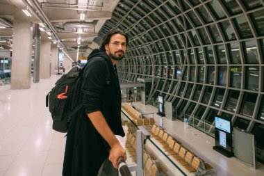 Havaalanının girişinde biniş için bekleyen bir adam. Sırt çantalı genç bir adam uçağa binmek için bekliyor.