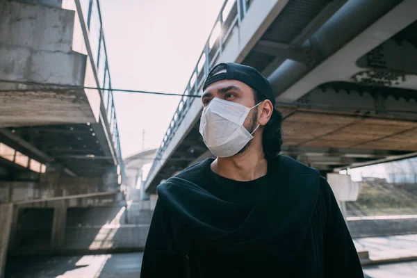 Homem Com Uma Máscara Médica Num Fundo Industrial Jovem Solitário — Fotografia de Stock