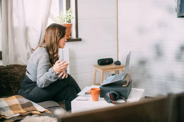 Een Vrouw Zit Woonkamer Met Een Laptop Kijkt Naar Het — Stockfoto