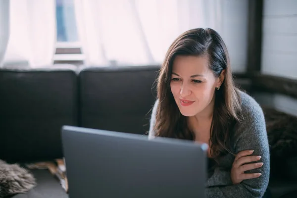 Een Vrouw Zit Woonkamer Met Een Laptop Kijkt Naar Het — Stockfoto