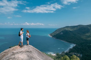 Okyanusun destansı manzarasına sahip bir çift kayanın üzerinde duruyor. Popüler bir turizm merkezi. Sevgililer tropik bölgelerde tatildeler. Tropiklerde balayı.