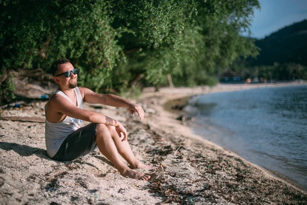 Парень Отдыхает Озере Закате Молодой Человек Сидит Воды Песчаном Берегу — стоковое фото
