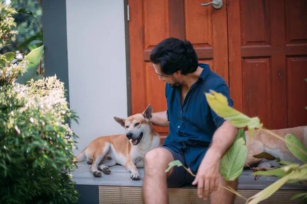 Ein Mann Mit Hunden Sitzt Auf Der Veranda Eines Hauses — Stockfoto