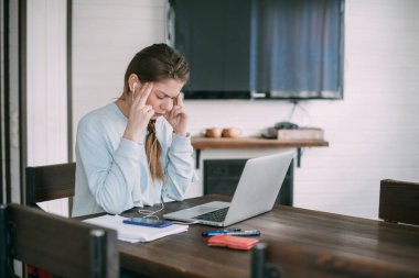 Dizüstü bilgisayarı olan hasta bir kadın oturma odasında çalışıyor. Baş ağrısı, ateş, kızda yorgunluk. Kişisel tecrit
