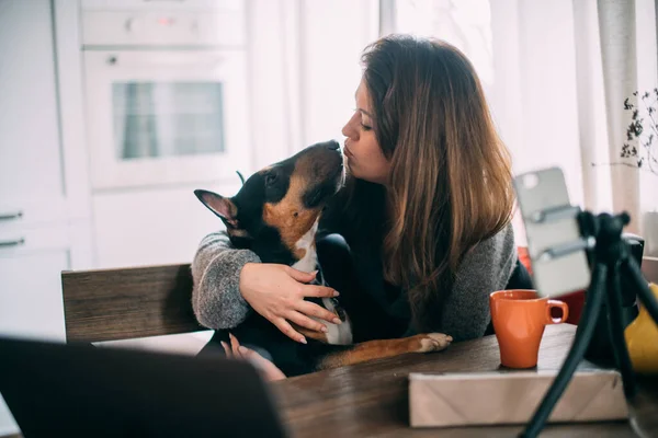 女人在网上聊天在家里和狗一起自私自利一个年轻的女孩被拍到与一只Rottweiler 女孩在电视上说话 拥抱一只狗 — 图库照片