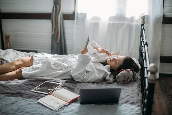 Una Mujer Descansa Una Cama Dormitorio Con Teléfono Una Joven —  Fotos de Stock