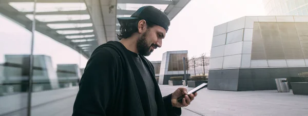 無人の大都市で彼の手に電話を持つ男 空の大都市の路上で人のいないスマートフォンを見ている若い男 — ストック写真