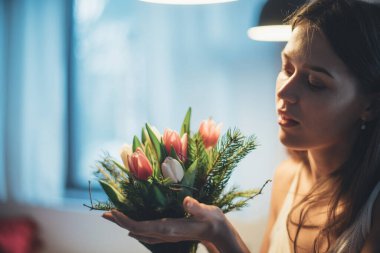 Bir kadının ellerinde bir buket çiçek. Uluslararası Kadınlar Günü. Genç bir kız lalelerin elinde topallıyor..