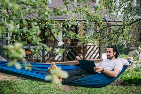 Ein Mann Arbeitet Mit Einem Laptop Einer Hängematte Einem Landhaus — Stockfoto