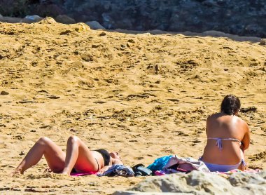 Kumsalda yatan genç kızlar