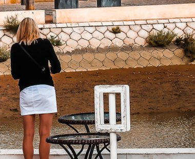 Şehirde beyaz etekli sarışın bir kadın.