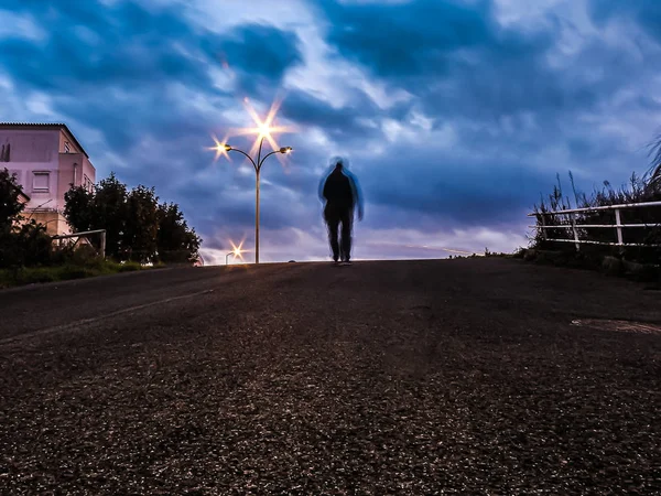 Akşam karanlığında hareketli bir karakterle yokuş aşağı bir sokak.