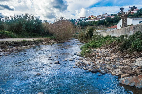 Rural landscape with a river and houses in the distance