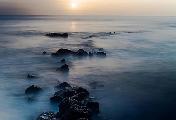 Πέτρες Που Βγαίνουν Από Κύματα Κοντά Στο Ηλιοβασίλεμα Στον Ωκεανό — Φωτογραφία Αρχείου