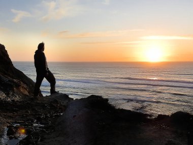 Gün batımına hayran bir adamın silueti.
