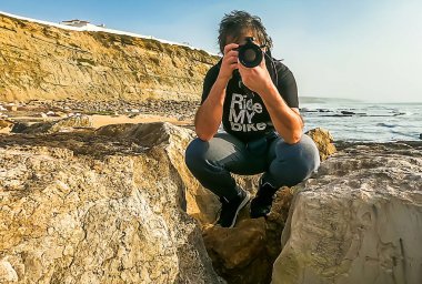 Rıhtımda fotoğraf çeken kameralı adam.