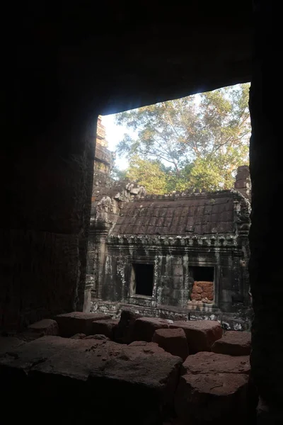 Old house in ancient angkor wat temple ruins seen through window in cambodia, asia — Stockfoto