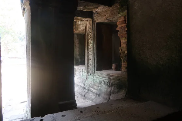 Slunce svítí oknem u kamenného sloupu se starobylými nástěnnými malbami ve slavných historických angkorských zříceninách, Kambodži — Stock fotografie