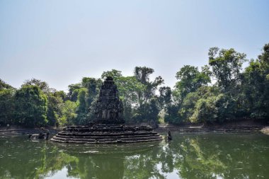 incredible reflection of temple and green jungle in beautiful old lake with clear water in angkor wat, cambodia