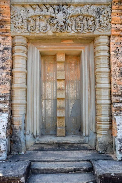 Belos baixos relevos símbolos na entrada da porta de pedra antiga para angkor wat templo em cambodia — Fotografia de Stock