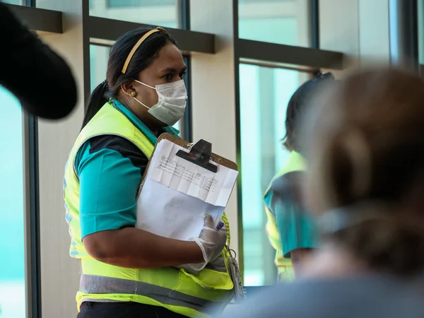 San Jose, Costa Rica 22 marzo 2020: donna, personale aeroportuale con maschera che sembra turbato e preoccupato durante l'epidemia di coronavirus — Foto Stock