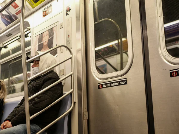 New York, United States, USA March 24, 2020: young man with mask sleeping in subway train in new york during coronavirus outbreak, virus pandemic — Stock Photo, Image