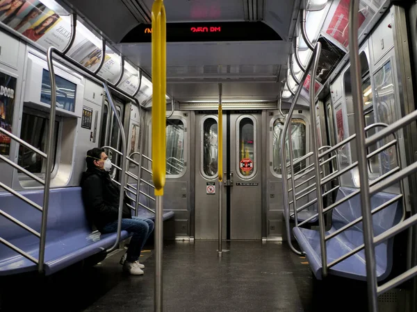 New York, United States, USA March 24, 2020: single man with mask siting in empty new york subway during coronavirus pandemic — Stock Photo, Image