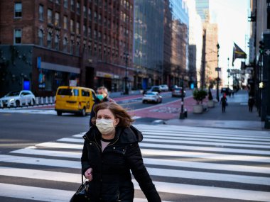 New York, ABD, 24 Mart 2020: Maskeli kadın covid 19 salgını sırasında New York caddesinde yürüyor.