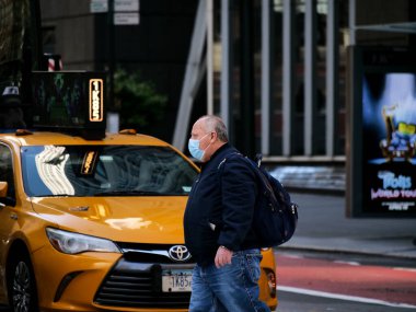 New York, ABD, ABD 26 Mart 2020: Coronavirus salgını sırasında New York taksisi önünde maskeli şişman bir adamın ikonik resmi