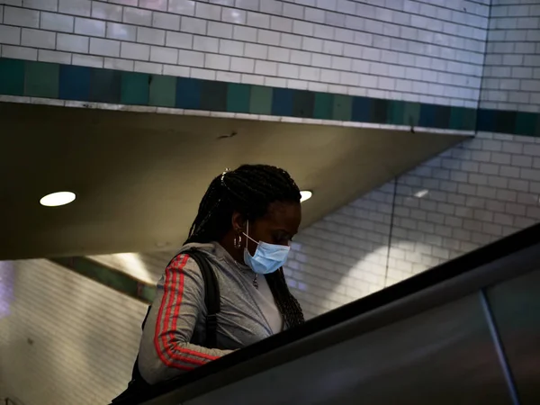 New York, Stati Uniti, Stati Uniti 24 marzo 2020: donna afroamericana con maschera da sola nella stazione della metropolitana durante l'epidemia di covid 19 — Foto Stock