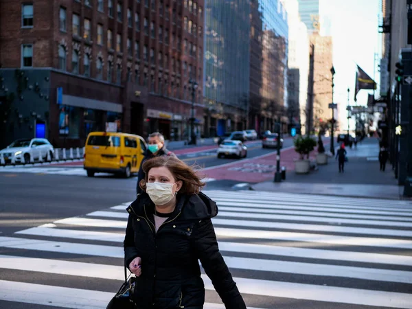 Nova York, Estados Unidos, EUA 24 de março de 2020: mulher com máscara andando na rua quase vazia de Nova York durante o covid 19 surto de pandemia — Fotografia de Stock