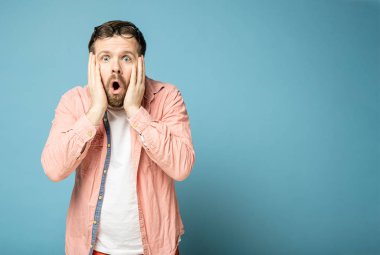 Kafasında gözlük olan şok olmuş bir adam şaşkınlıkla ağzını açtı ve fotokopi çekerek kameraya baktı. Mavi bir arkaplanda izole edilmiş